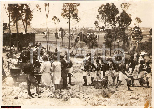 1933 Eritrea Asmara *Federale Guido Cortese al rancio Asmara, 1933Impero Coloniale Italiano, Colonia d'EritreaBella immagine d'epoca dell'allora segretario Federale Guido Cortese mentre assiste al rancio dopo la leva fascista.Vera fotografia d'epoca, originale e autentica.L'immagine non reca timbro datario al verso, ma risale con tutta probabilità all'anno 1933.L'immagine versa in buone condizioni malgrado presenti alcune bruniture e una macchia al margine inferiore destro (come da scansione). Di tali circostanze si è naturalmente tenuto conto nella determinazione del prezzo.------------------Nota storica: la città di Asmara fu occupata dall'Italia nel 1889 e divenne capitale della colonia nel 1897. Nel 1887 gli italiani, sotto la direzione dell'ingegnere E. Olivieri, costruirono la prima tratta della ferrovia che partendo da Massaua raggiungeva il forte militare di Saati, a poche decine di chilometri da Asmara. Successivamente, durante la amministrazione del Governatore F. Martini, la linea fu prolungata, sotto la direzione dell'ingegnere F. Shupfer, fino ad Asmara, raggiunta nel dicembre del 1911, passando attraverso la città di Ghinda. Fin dagli anni venti, grazie al governatore trevigiano Jacopo Gasparini, ma ancor più nel decennio successivo, il profilo architettonico della città mutò radicalmente, con la costruzione di nuove strutture ed edifici in stile razionalista, che portarono la città ad essere soprannominata "Piccola Roma". L'edilizia degli venti e anni trenta e la presenza coloniale italiana sono ancora oggi ben rintracciabili, sia nei principali edifici della città, sia nel nome di numerosi locali pubblici ed esercizi commerciali ("Bar Vittoria", "Pasticceria moderna", "Casa del formaggio", "Ferramenta", "Casa degli Italiani").Tra gli edifici più notevoli del periodo coloniale fascista da segnalare il Cinema Impero, costruito nel 1937 e considerato uno dei esempi più emblematici in stile Art Déco, e la stazione di servizio Fiat Tagliero, un impressionante edificio in stile futurista costruito nel 1938 a forma di aeroplano e dotato di due incredibili "ali" autoportanti che destano viva impressione ancora oggi.Il 1 aprile 1941, durante la II Guerra Mondiale, Asmara fu occupata, insieme al resto dell'Eritrea, dalle truppe britanniche del generale William Platt. originale e autentica 1 1933 Eritrea Asmara *Federale Guido Cortese al rancio Asmara, 1933Impero Coloniale Italiano, Colonia d'EritreaBella immagine d'epoca dell'allora segretario Federale Guido Cortese mentre assiste al rancio dopo la leva fascista.Vera fotografia d'epoca, originale e autentica.L'immagine non reca timbro datario al verso, ma risale con tutta probabilità all'anno 1933.L'immagine versa in buone condizioni malgrado presenti alcune bruniture e una macchia al margine inferiore destro (come da scansione). Di tali circostanze si è naturalmente tenuto conto nella determinazione del prezzo.------------------Nota storica: la città di Asmara fu occupata dall'Italia nel 1889 e divenne capitale della colonia nel 1897. Nel 1887 gli italiani, sotto la direzione dell'ingegnere E. Olivieri, costruirono la prima tratta della ferrovia che partendo da Massaua raggiungeva il forte militare di Saati, a poche decine di chilometri da Asmara. Successivamente, durante la amministrazione del Governatore F. Martini, la linea fu prolungata, sotto la direzione dell'ingegnere F. Shupfer, fino ad Asmara, raggiunta nel dicembre del 1911, passando attraverso la città di Ghinda. Fin dagli anni venti, grazie al governatore trevigiano Jacopo Gasparini, ma ancor più nel decennio successivo, il profilo architettonico della città mutò radicalmente, con la costruzione di nuove strutture ed edifici in stile razionalista, che portarono la città ad essere soprannominata "Piccola Roma". L'edilizia degli venti e anni trenta e la presenza coloniale italiana sono ancora oggi ben rintracciabili, sia nei principali edifici della città, sia nel nome di numerosi locali pubblici ed esercizi commerciali ("Bar Vittoria", "Pasticceria moderna", "Casa del formaggio", "Ferramenta", "Casa degli Italiani").Tra gli edifici più notevoli del periodo coloniale fascista da segnalare il Cinema Impero, costruito nel 1937 e considerato uno dei esempi più emblematici in stile Art Déco, e la stazione di servizio Fiat Tagliero, un impressionante edificio in stile futurista costruito nel 1938 a forma di aeroplano e dotato di due incredibili "ali" autoportanti che destano viva impressione ancora oggi.Il 1 aprile 1941, durante la II Guerra Mondiale, Asmara fu occupata, insieme al resto dell'Eritrea, dalle truppe britanniche del generale William Platt. originale e autentica 1